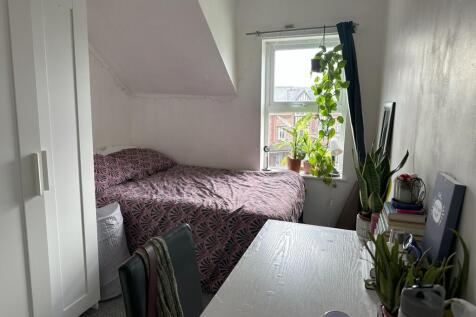 A cozy and well-lit double bedroom featuring a ...