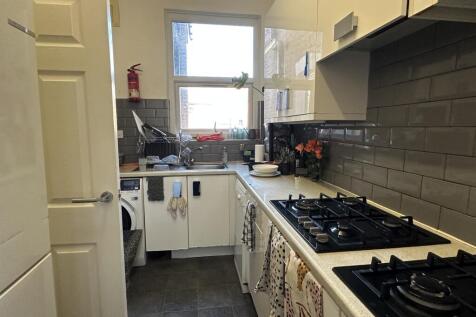 A modern and tidy kitchenette with ample natura...