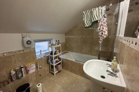 A well-maintained bathroom featuring a bath and...
