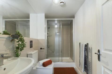 A clean and modern bathroom featuring a shower,...