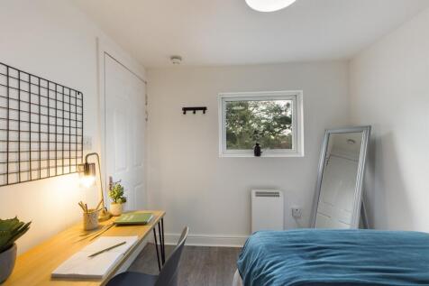 A bright and tidy double bedroom featuring a co...