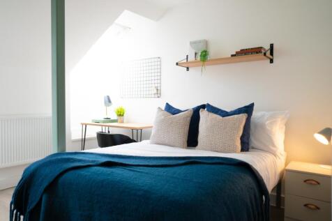 A bright and inviting double bedroom with styli...