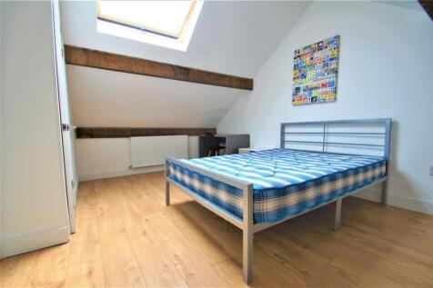 A charming double bedroom featuring a comfortab...