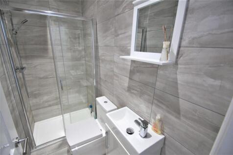 This modern bathroom features sleek gray tiles,...