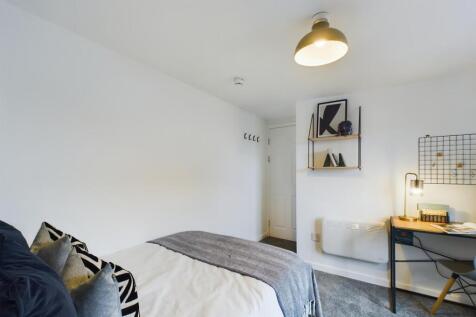 A bright and stylish double bedroom featuring a...
