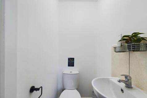 A clean and tidy single toilet with modern fixt...