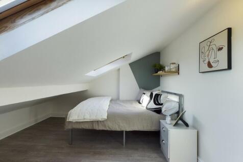A stylish and cozy double bedroom featuring nat...