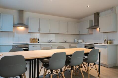 A spacious and modern kitchen featuring ample c...