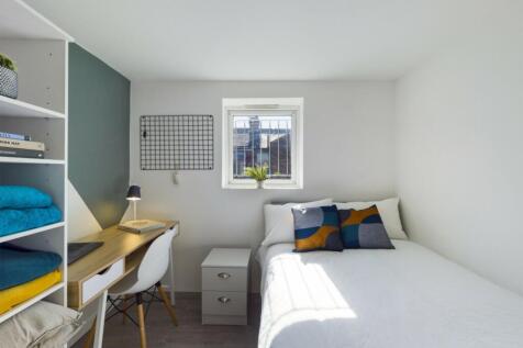 A bright and inviting double bedroom with a coz...