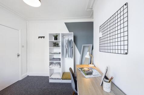 A bright and tidy double bedroom featuring a st...