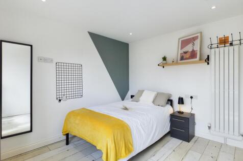 A bright and stylish double bedroom featuring m...