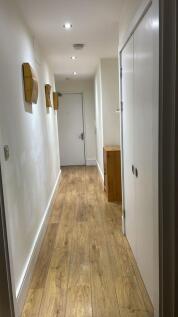 This spacious hallway features warm wooden floo...