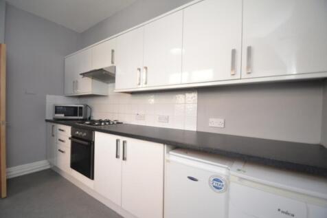 Modern kitchen featuring sleek white cabinetry,...