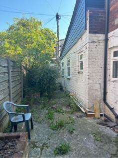 A charming garden area featuring a mix of green...