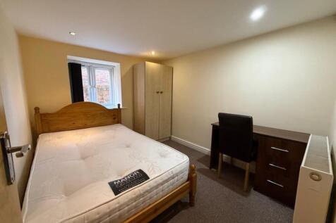 This inviting double bedroom features a comfort...