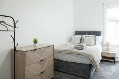 This cozy double bedroom features a comfortable...