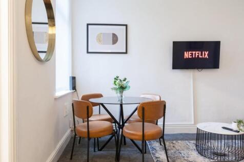 A stylish communal lounge featuring a modern ro...