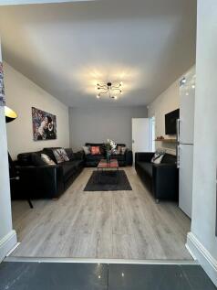 Spacious and stylish living room featuring comf...