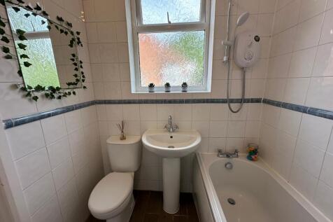 A well-maintained bathroom featuring a bathtub ...