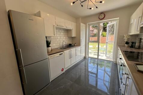 Bright and modern kitchen featuring sleek cabin...