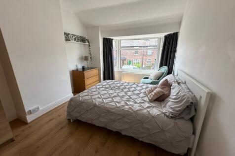 This inviting double bedroom features a comfort...
