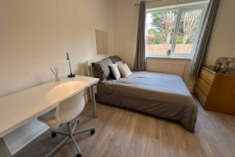 Spacious double bedroom featuring large windows...