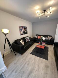 Spacious and stylish living room featuring comf...