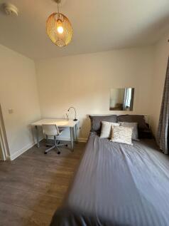 This inviting double bedroom features a comfort...