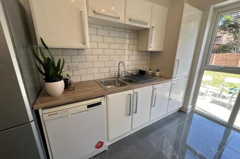 Bright and modern kitchen featuring sleek cabin...