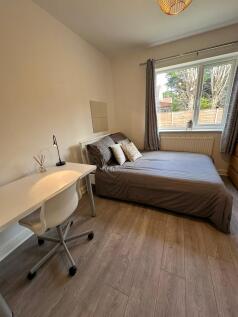 This inviting double bedroom features a comfort...