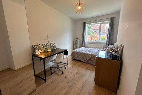 This inviting double bedroom features a comfort...