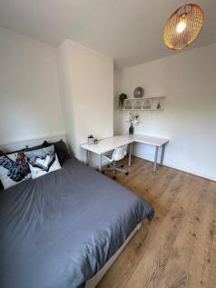 This inviting double bedroom features a comfort...