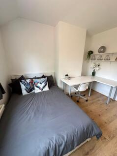 This inviting double bedroom features a comfort...
