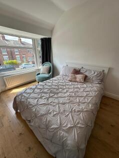 This inviting double bedroom features a comfort...
