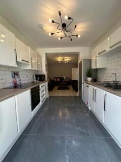 A modern kitchen featuring sleek white cabinetr...