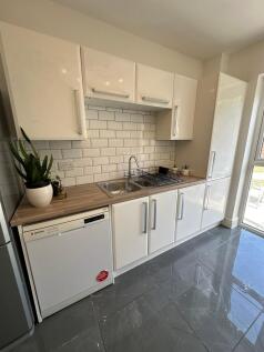 Modern kitchen featuring sleek cabinetry, ample...