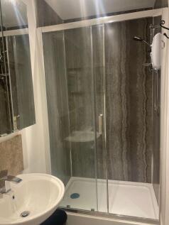 This modern bathroom features a sleek glass sho...