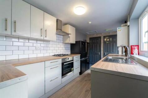 A modern kitchen featuring sleek cabinetry, a s...