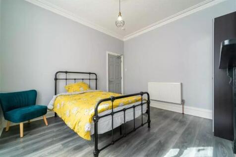 This charming double bedroom features a cozy at...