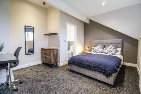 This inviting double bedroom features a cozy at...