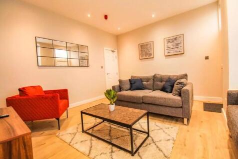 A stylish living room featuring a cozy grey sof...