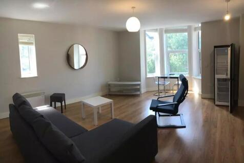 Bright and spacious living room featuring large...
