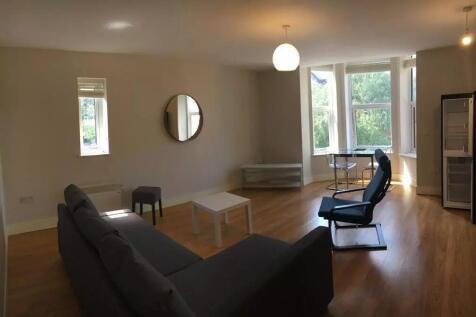 A bright and spacious living room featuring lar...