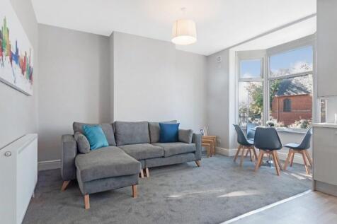 Bright and spacious living room featuring large...