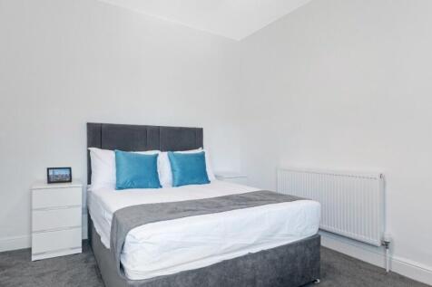 This inviting double bedroom features a comfort...