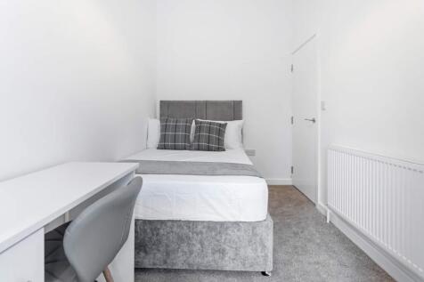 This inviting double bedroom features a comfort...