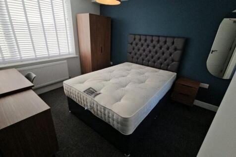 This stylish double bedroom features a comforta...