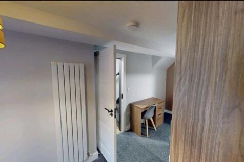 This inviting double bedroom features a cozy de...