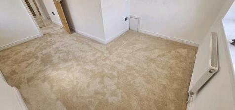 A well-maintained hallway featuring plush carpe...
