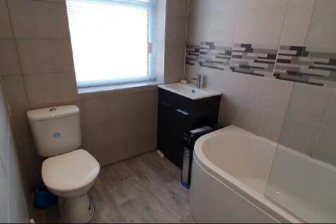 A modern bathroom suite featuring a curved bath...